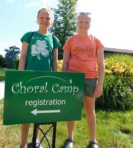 Two Girls Behind the Choral Camp Sign